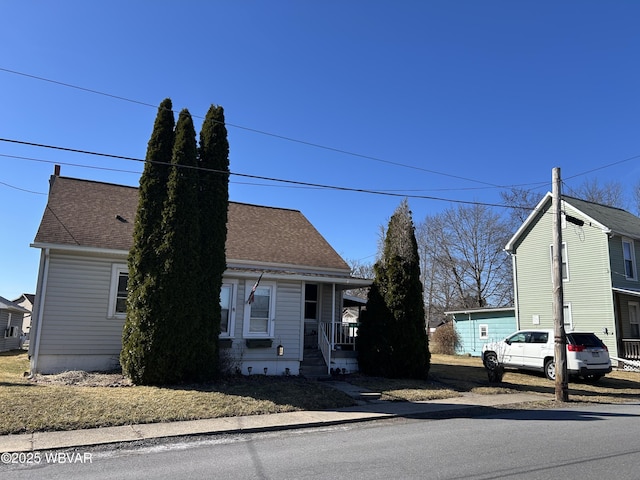 view of front of house with covered porch and a shingled roof