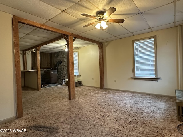 325 Washington Ave, Jersey Shore, PA 17740 - unfurnished living room with a wood stove, carpet, a paneled ceiling, a ceiling fan, and baseboards