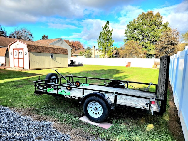 view of yard with an outbuilding, a storage unit, and a fenced backyard