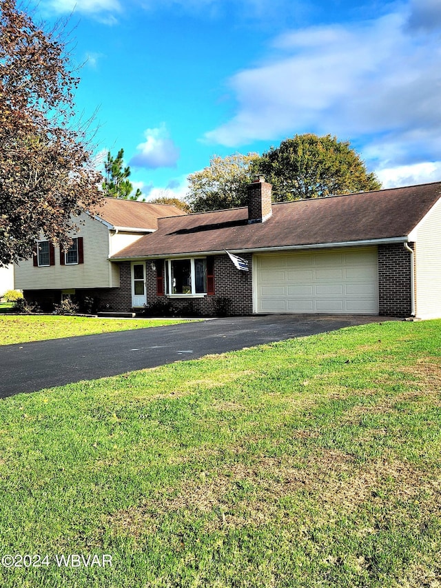 split level home featuring a front lawn, aphalt driveway, and brick siding