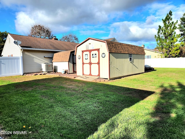 view of shed with fence and central AC