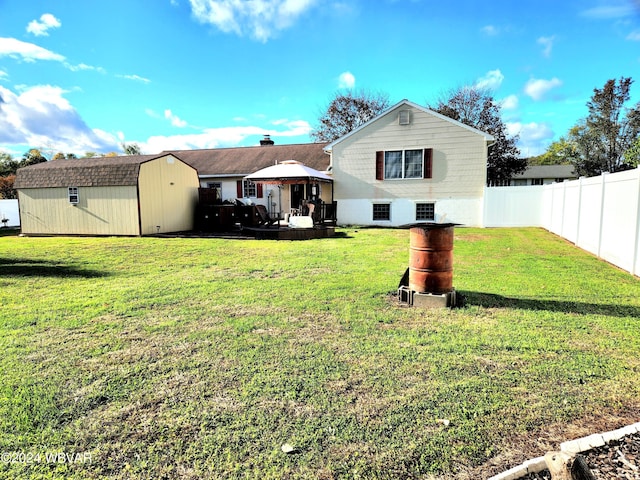 back of property with a lawn, a fenced backyard, a gazebo, an outdoor structure, and a shed