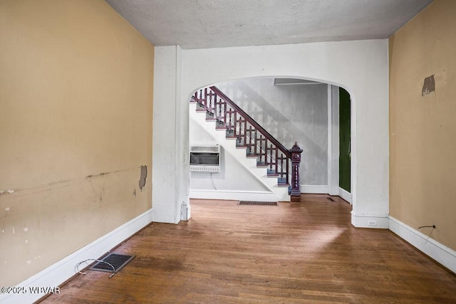 152 Carpenter St, Dushore, PA 18614 - unfurnished room featuring wood finished floors, arched walkways, stairway, and heating unit