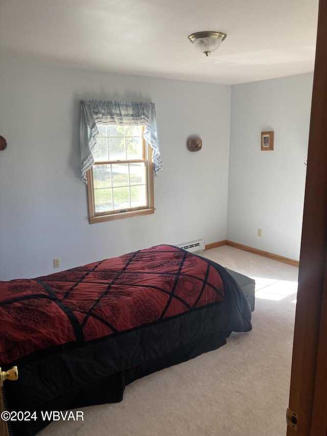 bedroom with a baseboard heating unit, carpet flooring, and baseboards