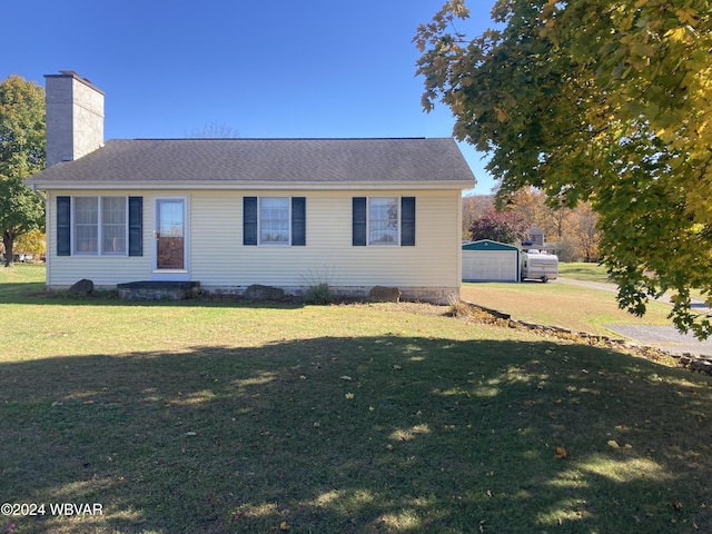 view of front of house featuring an outbuilding, a front yard, and a garage