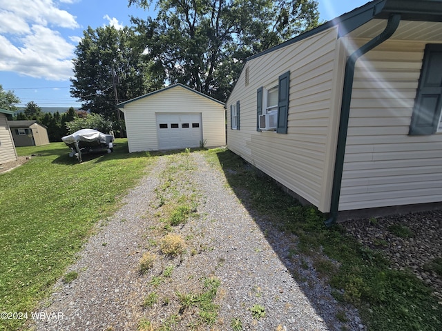 view of home's exterior with a garage, cooling unit, an outdoor structure, and a lawn