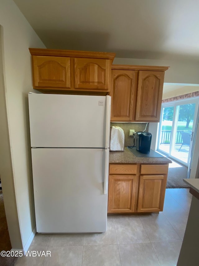 29 S Parsons Dr, Mill Hall, PA 17751 - kitchen featuring freestanding refrigerator, backsplash, light countertops, light tile patterned flooring, and brown cabinetry