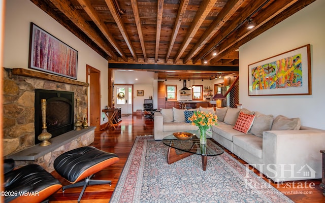 living room with track lighting, a fireplace, beamed ceiling, wood-type flooring, and wood ceiling