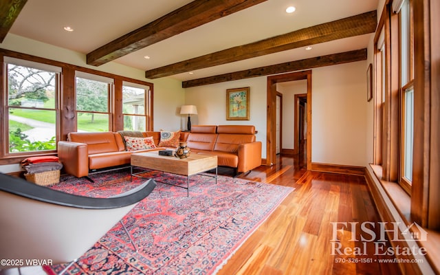 living room featuring beamed ceiling and light hardwood / wood-style floors