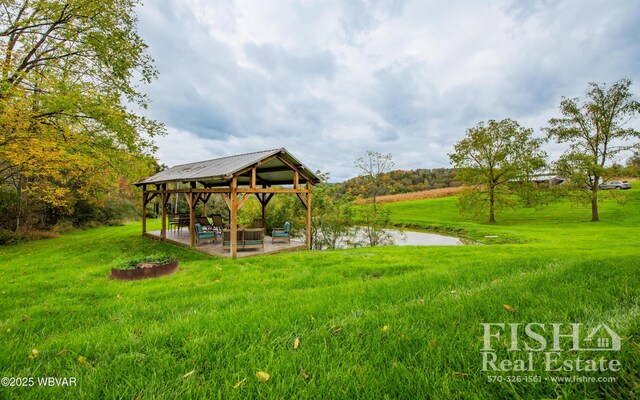 view of home's community with a gazebo, a yard, a water view, and a patio