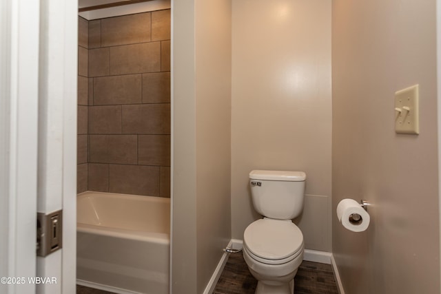 bathroom featuring hardwood / wood-style flooring, a bathing tub, and toilet