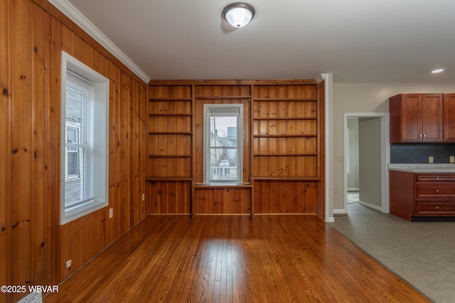 interior space featuring crown molding, hardwood / wood-style floors, and wood walls