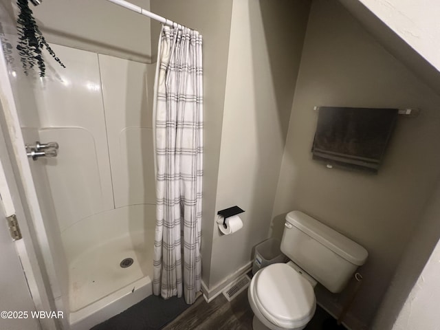 bathroom featuring a shower with curtain, hardwood / wood-style flooring, and toilet