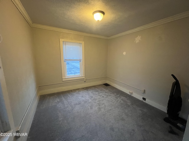 spare room with dark colored carpet, a textured ceiling, and ornamental molding