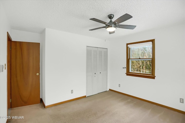 unfurnished bedroom featuring ceiling fan, light carpet, and a closet