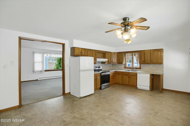 kitchen with ceiling fan, sink, baseboard heating, white appliances, and decorative backsplash