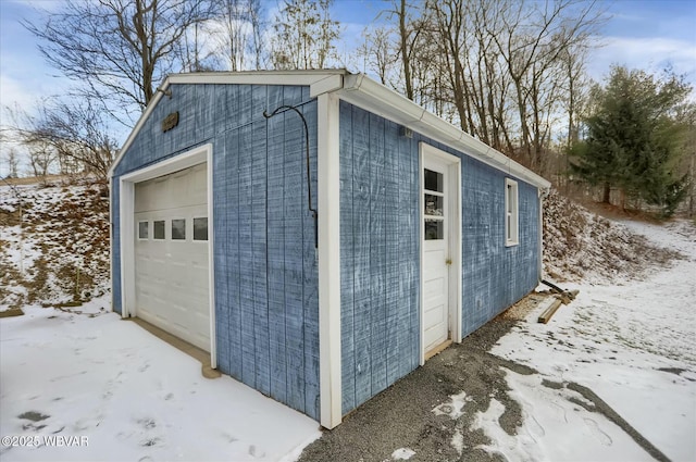 snow covered structure with a garage