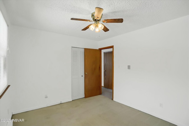 carpeted spare room with ceiling fan and a textured ceiling