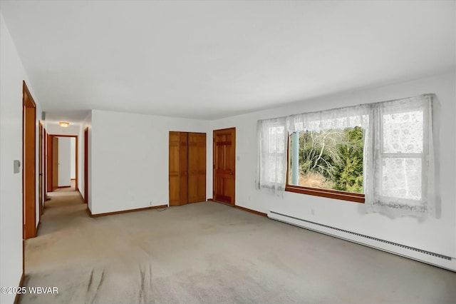 empty room with light colored carpet and a baseboard heating unit