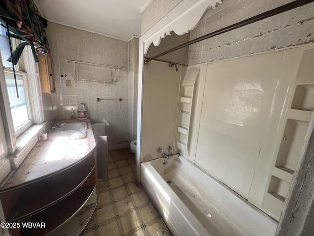 full bath with tile patterned floors, toilet, shower / tub combination, tile walls, and vanity