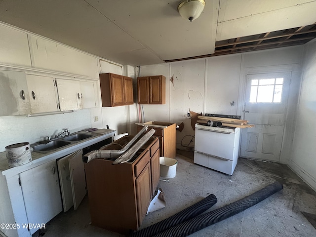 kitchen with stove, brown cabinets, and a sink