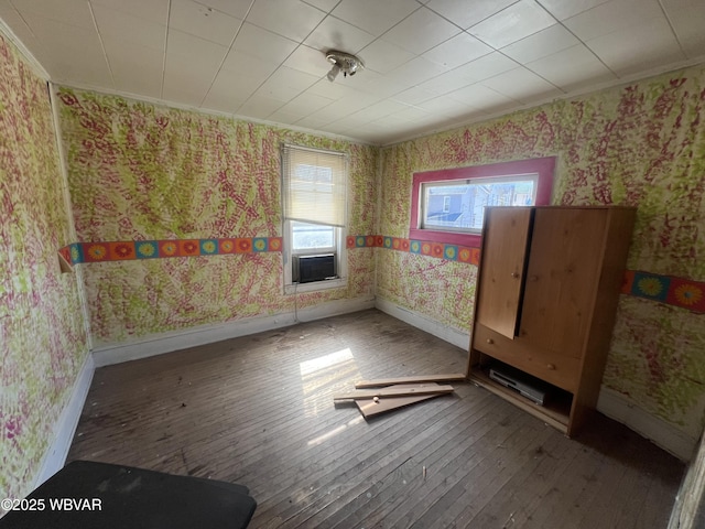 spare room with wallpapered walls, crown molding, baseboards, cooling unit, and hardwood / wood-style flooring