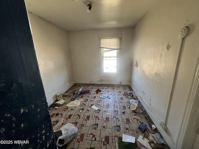 empty room featuring tile patterned floors and baseboards