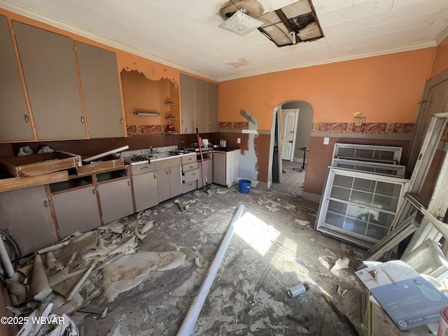 kitchen featuring arched walkways and ornamental molding