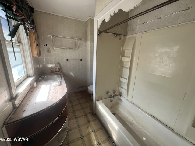 full bath featuring vanity, tub / shower combination, tile patterned floors, toilet, and tile walls