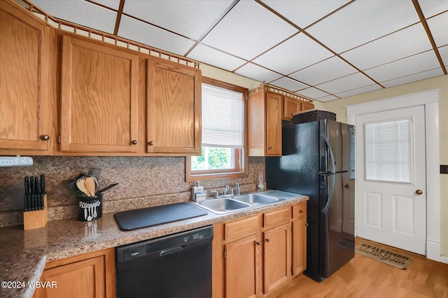 kitchen with sink, a drop ceiling, light hardwood / wood-style flooring, backsplash, and black appliances