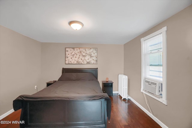 bedroom featuring radiator heating unit, cooling unit, and dark wood-type flooring