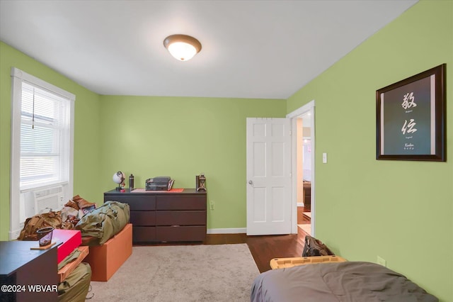 bedroom with hardwood / wood-style floors and cooling unit