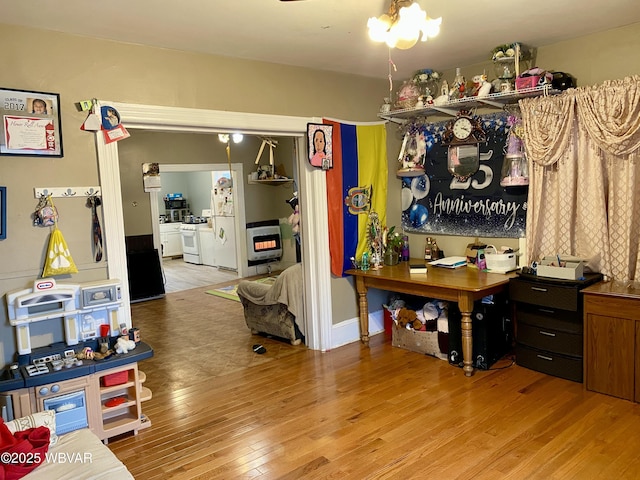 interior space featuring heating unit, light wood-type flooring, and a notable chandelier