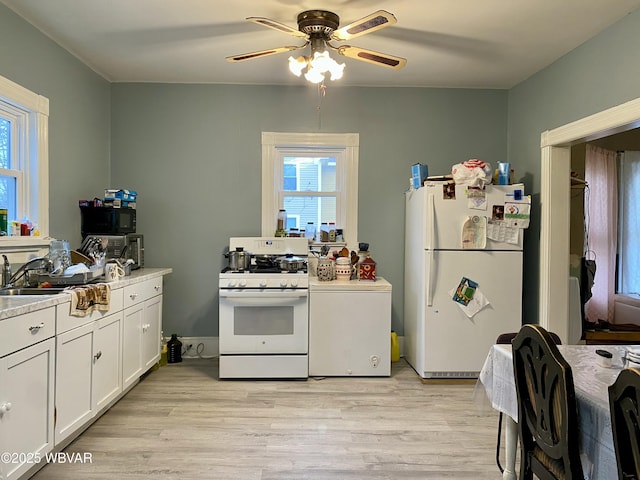 kitchen featuring white appliances, white cabinetry, sink, ceiling fan, and light hardwood / wood-style flooring