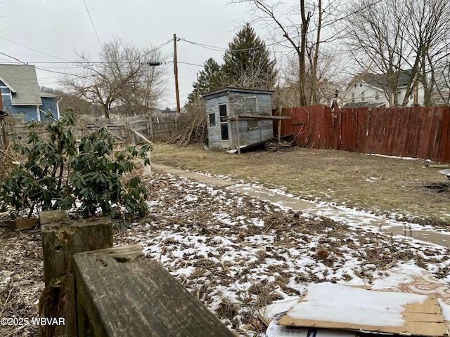 snowy yard with a storage shed