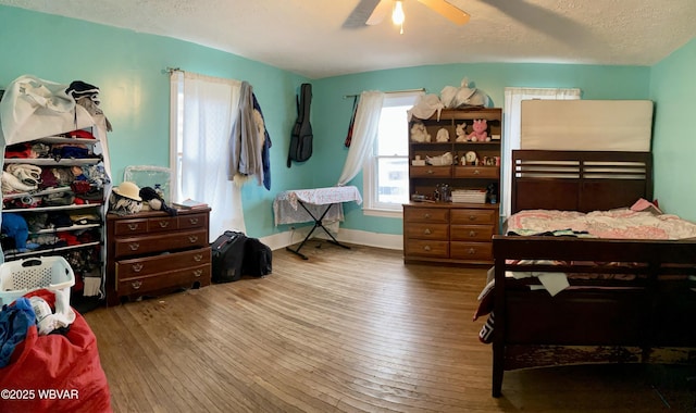 bedroom with ceiling fan, a textured ceiling, and hardwood / wood-style flooring