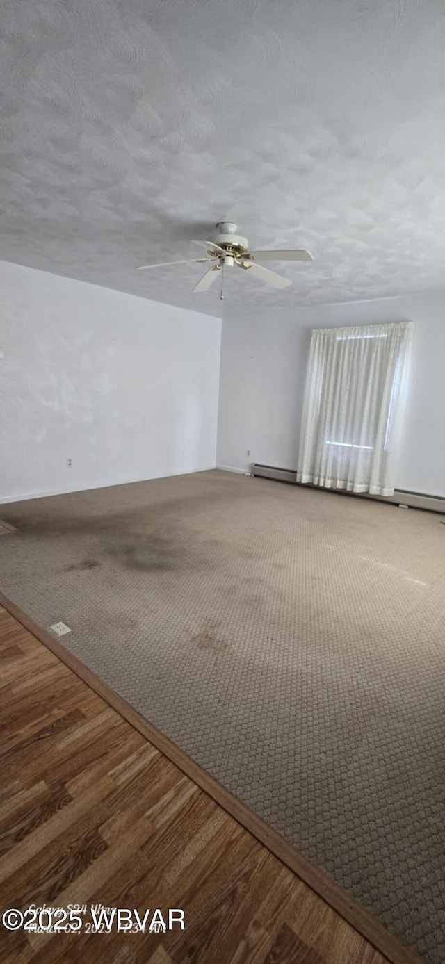 unfurnished room with wood finished floors, baseboard heating, and ceiling fan