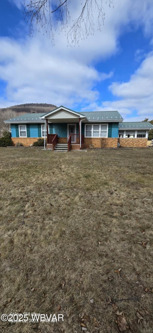 view of front of home featuring covered porch and a front yard