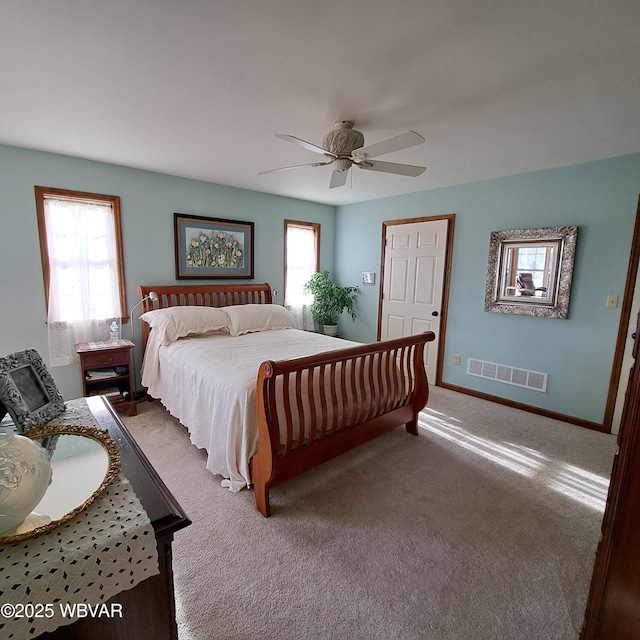 bedroom featuring visible vents, multiple windows, baseboards, and ceiling fan