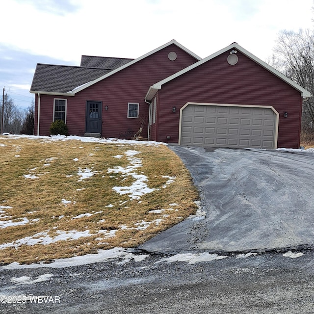 view of front facade featuring driveway, a shingled roof, and a garage