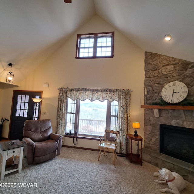 carpeted living room with a stone fireplace, plenty of natural light, baseboards, and high vaulted ceiling