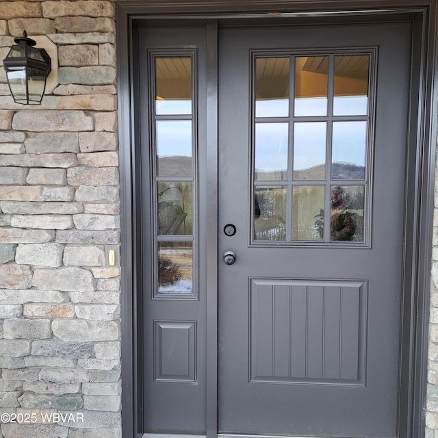 doorway to property with stone siding