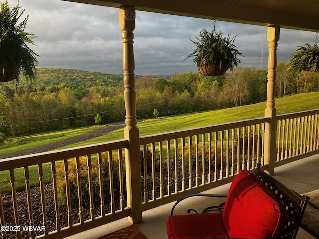 deck with a lawn and a view of trees