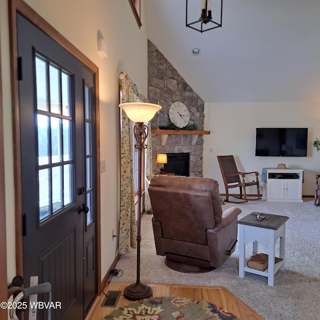 carpeted living room with vaulted ceiling, a fireplace, visible vents, and baseboards