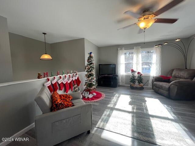 living room featuring hardwood / wood-style floors and ceiling fan