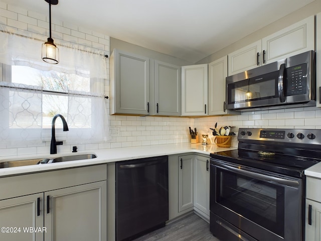 kitchen featuring sink, stainless steel appliances, dark hardwood / wood-style flooring, decorative light fixtures, and decorative backsplash