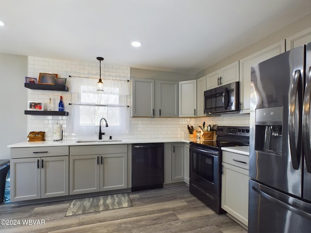 kitchen with gray cabinetry, hanging light fixtures, stainless steel appliances, and sink