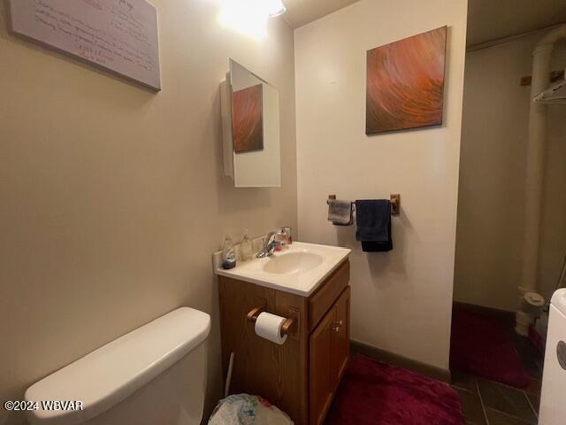 bathroom featuring tile patterned floors, vanity, and toilet