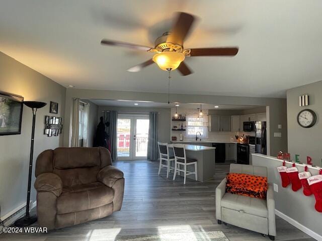 living room with ceiling fan, french doors, hardwood / wood-style floors, and sink