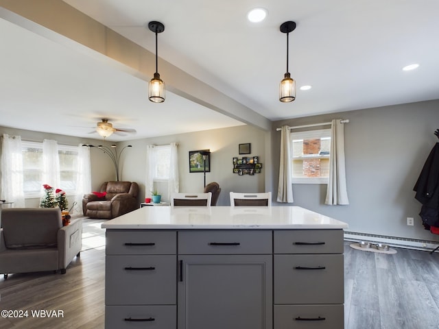 kitchen featuring pendant lighting, dark wood-type flooring, ceiling fan, and a baseboard heating unit